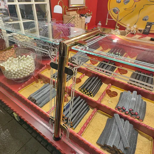 Anwendungsbeispiel: Hustenschutz/Spuckschutz Modell 20-120-38 mit Messing-Gold Pfosten (mittig) und senkrechter Glasabtrennung - ideal f�r Weihnachtsmarkt-S��warenst�nde sowie Metzgerei- und Lebensmitteltheken.