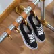 Anwendungsbeispiel Garderobe: Schwarze Sneaker an Relinghaken mit Lederschlaufe in Camel, daneben weitere Haken an der Rohrstange. Symbolfoto f�r den gro�en Lavane Relinghaken in Messing matt Design f�r Rohr � 19 und 25,4 mm.